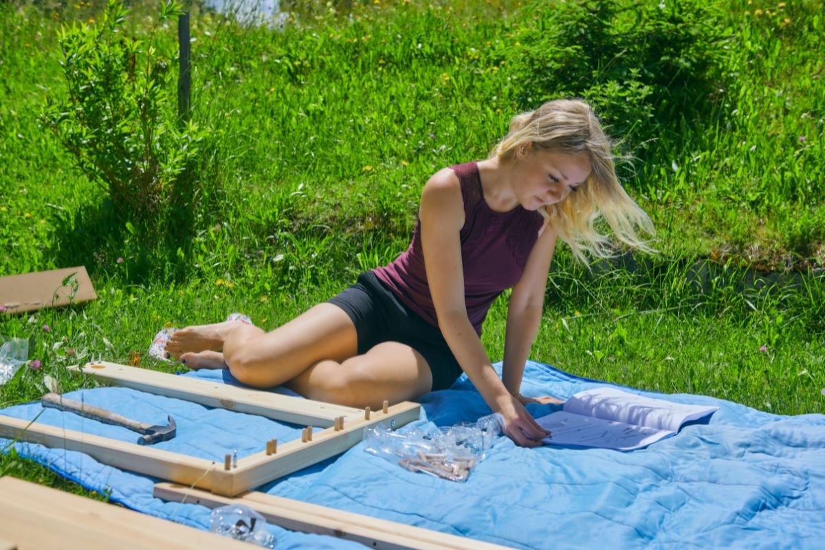 A woman sits on the grass beside a piece of wood, showcasing a natural setting for a furniture service advertisement.