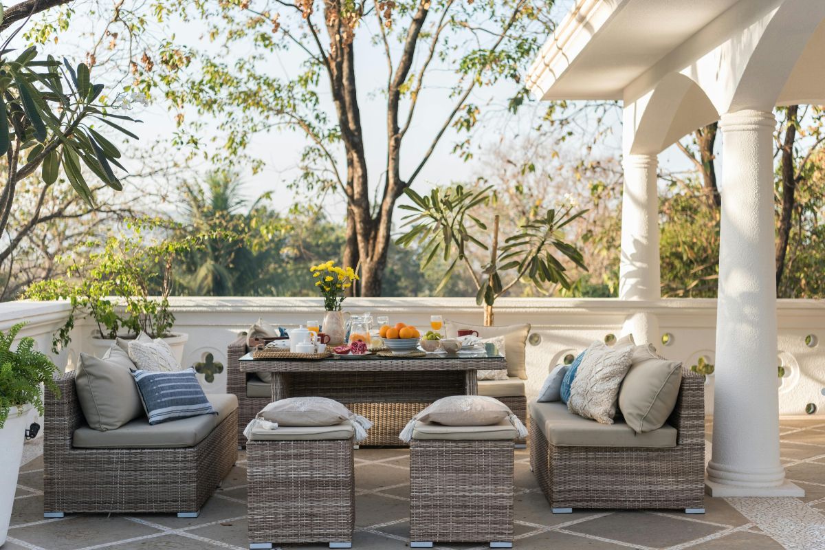  A patio featuring wicker furniture and a table, showcasing a cozy outdoor seating area for relaxation and dining.