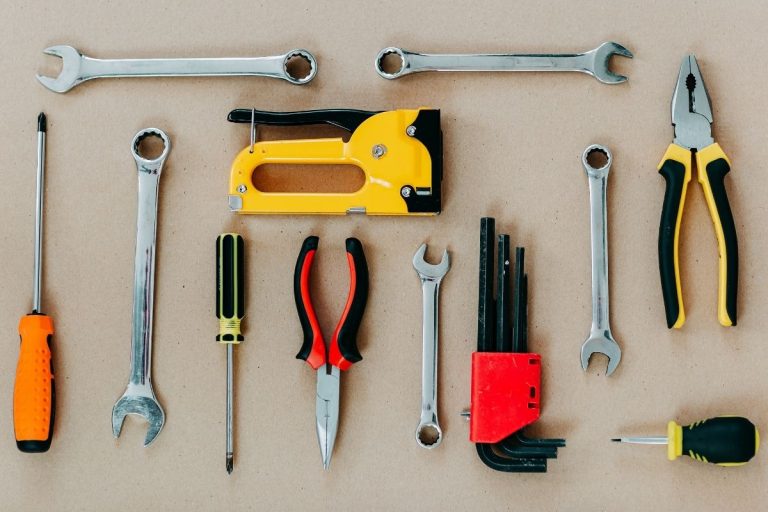 An assortment of tools displayed against a brown backdrop, highlighting their different designs and functionalities.